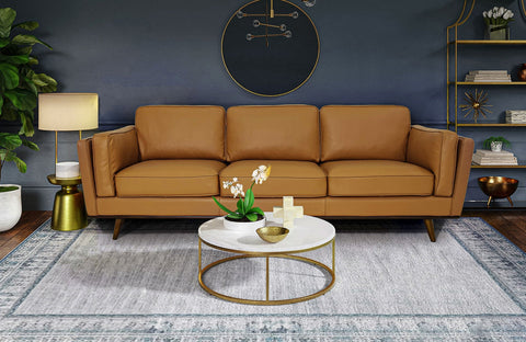 Modern living room setup showcasing how to furnish a new home with a stylish brown sofa, round coffee table, and decorative accents.