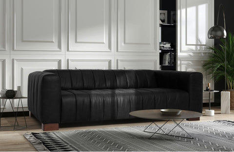 Elegant black sofa in luxurious living room setting, embodying What It Means to Nest in Style with modern decor.