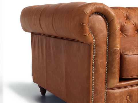 Side view of Stanhope Cognac Distressed Leather 4 Seater Chesterfield, showcasing luxurious aniline leather upholstery with nailhead trim.