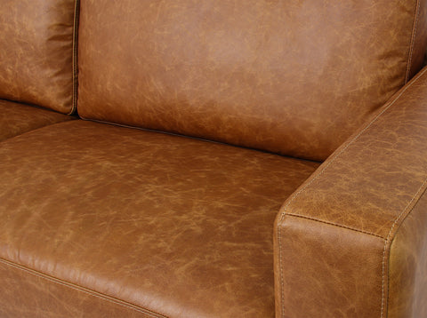Close-up of Amore Cognac Distressed Leather 3 seater sofa showcasing top-grain leather with matte finish.