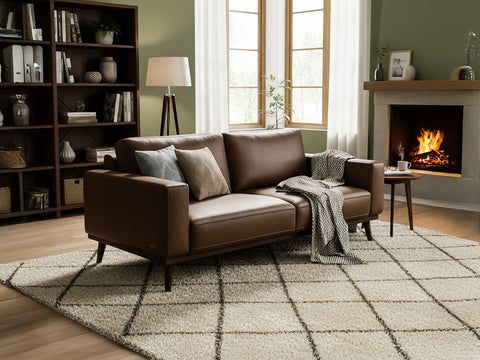 Amore Midcentury Chestnut Brown Leather 3 seater sofa in a cozy living room setting with a fireplace.