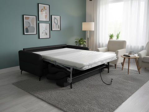 Elena Black Full Leather Sofa Bed set up as a full-size bed in a modern living room with soft lighting and decorative art.
