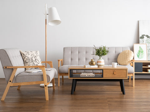 Living room with Lia Mid-Century Modern Oak Coffee Table with Drawer, Nordic style decor, wooden floor, and gray furniture.