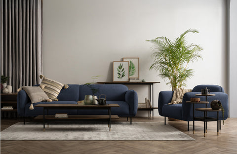 Livia Navy Blue Firm Accent Chair in stylish living room setting with cozy sofa, black metal legs, and modern decor.