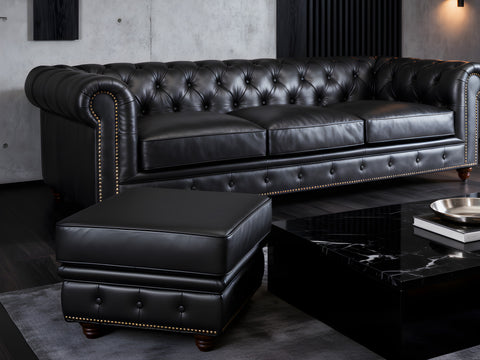 Stanhope Black Leather Chesterfield Ottoman in elegant modern living room setting, showcasing luxury and refined British design.