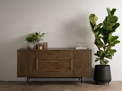 Nero Mid-Century Fluted Door Sideboard with Brass Handles in a modern minimalist setting with plants and books.
