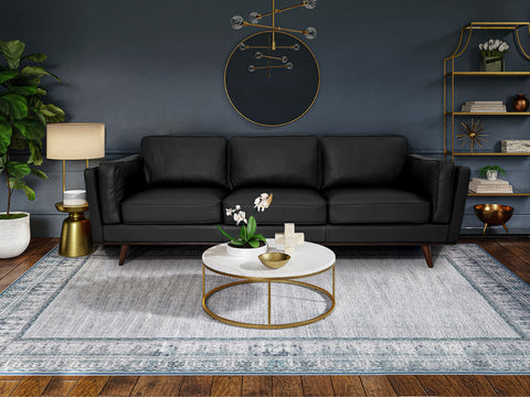 Selina Mid-Century Leather Black 3-Seater Sofa displayed in a modern living room setting with decorative elements.