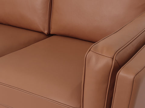 Close-up of Selina Midcentury Brown Leather Loveseat Sofa showcasing soft leather cushions and structured armrest.