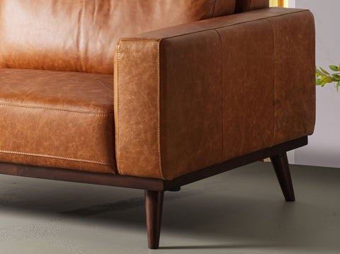 Close-up of a stylish sofa upholstered in distressed leather, showcasing the texture and timeless appeal of distressed leather furniture.