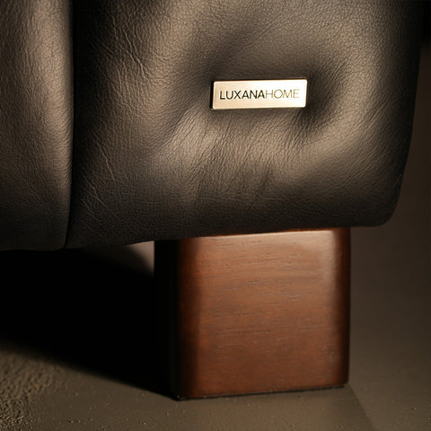Luxury sofa detail from a local Canadian furniture brand with a metal label, showcasing premium craftsmanship in leather and wood.