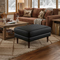 Selina Midcentury Black Leather Ottoman in cozy living room setting