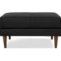 Selina Midcentury Black Leather Ottoman in premium full top-grain semi-aniline leather with elegant wooden legs and matte finish.