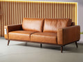 Luxury Amore Cognac Distressed Leather 3 seater sofa with teak oak legs in modern living room setting.