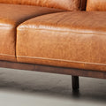 Close-up of Amore Cognac Distressed Leather 3 seater sofa showcasing full-aniline leather and tapered teak oak legs.
