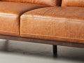 Close-up of Amore Cognac Distressed Leather 3 seater sofa showcasing full-aniline leather and tapered teak oak legs.
