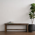 Annata Rustic Bench - Dark Solid Wood showcased in minimalist setting with a potted plant