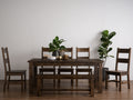 Annata Rustic Dining Table - Dark Solid Wood surrounded by matching dark wood chairs and bench in a cozy dining room setting.