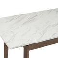 Close-up view of the Caldo Extendable dining table with a white marble-look laminate top and cocoa oak legs.