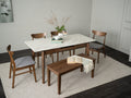 Caldo Extendable dining table set in a modern dining room with marble top and wooden chairs