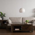Caro Rustic Coffee Table - Dark Solid Wood in modern living room setting with plants and beige sofa