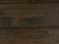 Close-up view of dark solid wood texture from the Caro Rustic Coffee Table - Dark Solid Wood showcasing rich grain patterns.