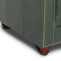 Close-up of the Stanhope Royal Green Leather 4 Seater Chesterfield corner with nailhead trim and wooden legs.