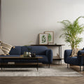 Livia Navy Blue Firm Accent Chair in stylish living room setting with cozy sofa, black metal legs, and modern decor.