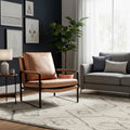 Luna Modern Leather Tan Accent Chair in a cozy living room setting with a lamp and grey sofa.