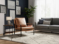 Luna Modern Leather Tan Accent Chair in a cozy living room setting with a lamp and grey sofa.