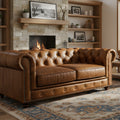 Stanhope Cognac Distressed Leather Loveseat Chesterfield in cozy living room setting with fireplace and elegant decor.