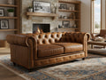 Stanhope Cognac Distressed Leather Loveseat Chesterfield in cozy living room setting with fireplace and elegant decor.