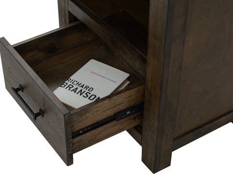 Open drawer of Pia Rustic Bookcase - Dark Solid Wood showcasing storage space with a book inside.