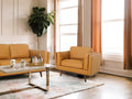Selina Midcentury Cognac Leather Accent Chair in a stylish living room with modern decor and warm tones.