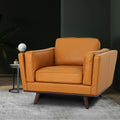 Selina Midcentury Cognac Leather Accent Chair in a modern living space with greenery and stylish decor.