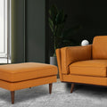 Selina Midcentury Cognac Leather Ottoman paired with a modern sofa in a stylish living room setting.