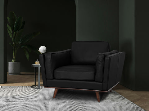 Selina Midcentury Black Leather Accent Chair in a modern living space with greenery and stylish decor.