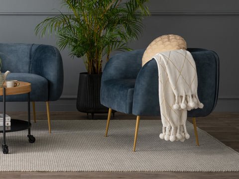 Modern living room with Soffio Glam Mid-Century Modern Velvet Accent Chair in blue velvet and gold legs, accented by plants and cozy decor.