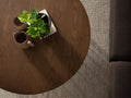 Top view of Sogno Round Wood Top Metal Caged Base Coffee Table with plants and mugs, showcasing wood grain texture.