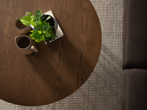 Top view of Sogno Round Wood Top Metal Caged Base Coffee Table with plants and mugs, showcasing wood grain texture.