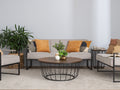 Sogno Round Wood Top Metal Caged Base Coffee Table in modern living room setting with plants and cushions.