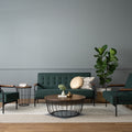 Sogno Round Wood Top Metal Caged Base Coffee Table in modern living room setup with green sofas and decor.
