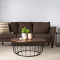 Living room scene with Sogno Round Wood Top Metal Caged Base Coffee Table in front of brown sofa and side table.