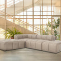 Tuscono Beige Leather Low Profile Modular Sofa in a modern setting with lush greenery and natural light.